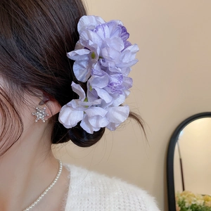 Detail of elegant purple fabric flower hairpin with soft silk texture and realistic petals