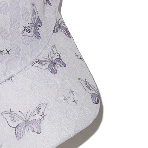Close-up of white lace baseball cap featuring purple butterfly patterns and star details