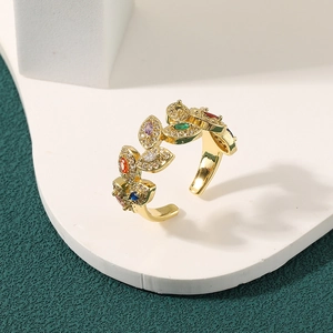 Detailed close-up of 18K gold-plated leaf ring with colorful crystals on a display