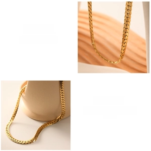 Macro detail of high-polish flat snake chain necklace in 18k gold-plated stainless steel