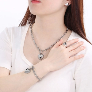 Close-up of a silver stainless steel heart jewelry set featuring a necklace and bracelet