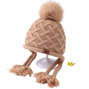 Light brown children's knit earflap hat with fluffy pompom and braided tassels