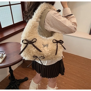 Detailed view of beige faux fur shoulder bag with decorative brown leather bows