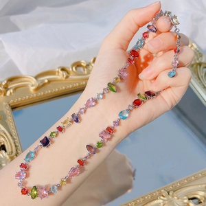 Close-up of rainbow crystal necklace with mixed-cut gemstones on a silver setting