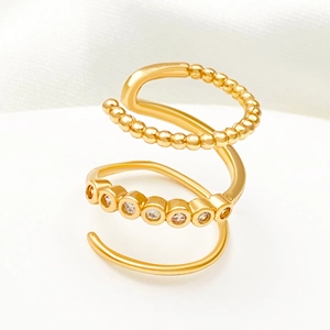 Modern layered gold spiral ear cuff featuring bead texture and sparkling crystal accents