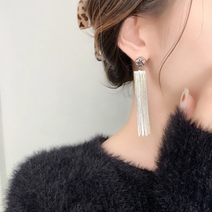 Elegant silver long chain tassel earrings in 18K gold plated copper on a model's ear