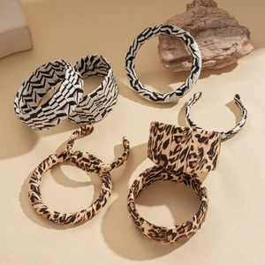 Faux leather leopard and zebra print open cuffs and bangles on neutral background