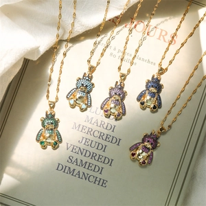 Detailed view of colorful rhinestone bear pendants in five colors on a golden chain