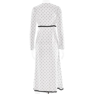 Detail view of white polka dot dress featuring black lace trim on waist and hemline
