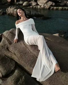 Detail of elegant off-shoulder white mesh dress with fine pleats and long sheer sleeves