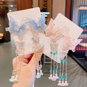Detailed view of handmade butterfly hair clips with long tassels and beads for girls