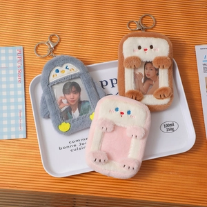 Detail of plush animal card holders including penguin and rabbit designs on a white tray