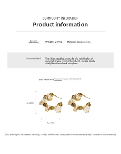 Detail view of large C-shaped hoop earrings featuring resin marble beads and gold spheres