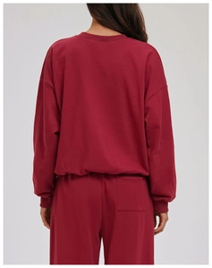 Detail view of the back of a dark red crewneck sweatshirt and joggers set with back pocket