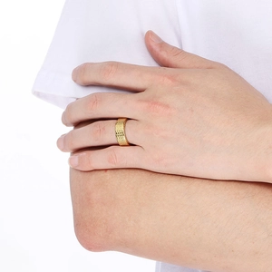 Detailed close-up of a gold-plated textured ring featuring a woven diamond pattern on a finger