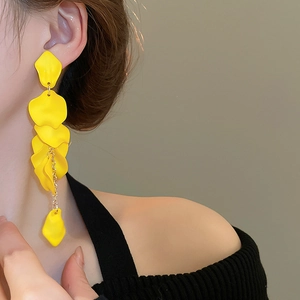 Close-up of elegant yellow rose petal tassel earrings on model with golden chains