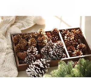 Close-up of mixed natural and gold pine cones in a wooden tray for festive DIY decoration