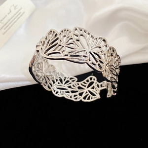 Detailed macro view of the silver cutout butterfly pattern and metallic texture on bracelet