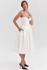 Dettaglio dell'abito midi bianco senza spalline con corpetto a corsetto e gonna a pieghe