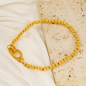 Bracelet élégant à billes dorées avec fermoir à ressort sur travertin et soie