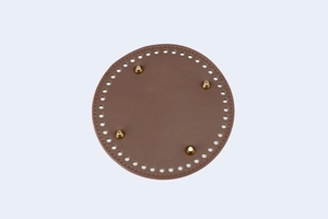 Detailed view of 15cm round brown PU leather bag base with golden metal feet and pre-cut holes