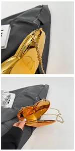 Macro detail of golden heart evening clutch with metallic finish and magnetic closure