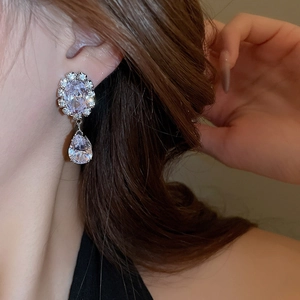 Side view of luxury silver teardrop earrings with clear cubic zirconia on model