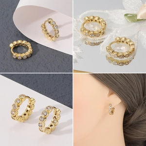 Detalle de pendientes de aro geométricos bañados en oro de 18K con circonitas redondas