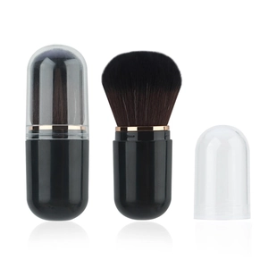 Detail view of the capsule retractable makeup brush showing the gold ring and cap