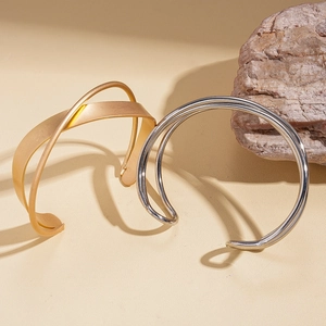 Crossed multi-layer open cuff bracelets in polished silver and matte gold finishes
