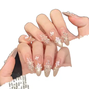 Long stiletto press-on nails with 3D white flowers, pearls, and champagne gold glitter