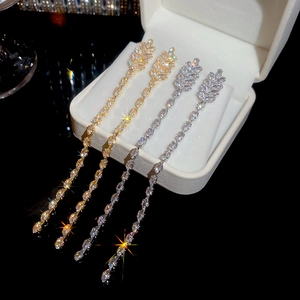 Detail view of 18K gold and silver plated chain tassel earrings with sparkling zircons