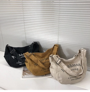 Sacs cabas en toile noir, jaune gingembre et blanc crème posés à plat devant volets
