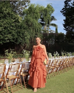 Chic backless halter neck tiered maxi dress in orange-red chiffon at a garden party