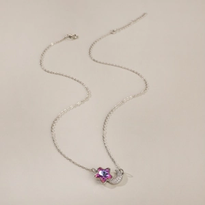 Primer plano del collar de plata con cristal de estrella rosa y colgante de luna de circón