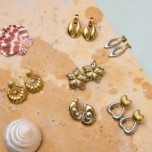Boucles d'oreilles vintage en acier inoxydable doré et argenté avec perles sur fond pierre