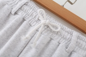Macro detail of elastic waistband and white drawstring on grey cotton tracksuit pants