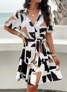 Detail of elegant geometric print dress featuring a lapel collar and button-up front design