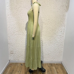 Detail of green floral backless tiered maxi dress with smocked bodice and tie straps