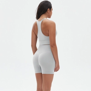 Dettaglio del set yoga grigio con reggiseno sportivo incrociato e pantaloncini a vita alta