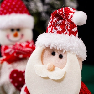 Close-up of knitted Santa Claus gift bag detail with soft 3D doll and festive textures