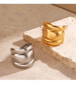 Close-up of gold and silver chunky wave rings with matte brushed texture on stone
