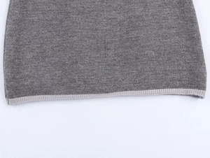 Detailed macro view of the grey knit fabric texture with fine contrast ribbed hem stitching