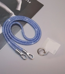 Detailed view of blue glitter crossbody phone strap with silver clips and clear patch