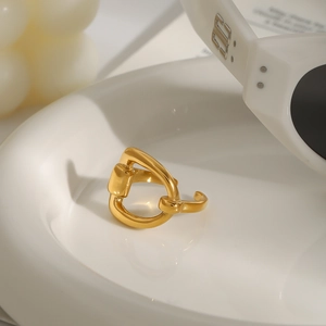 Polished 18k gold plated stainless steel horsebit ring on a white ceramic tray