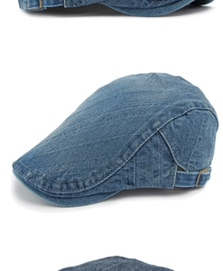 Detail of washed denim newsboy cap showing texture and metal adjustable buckle