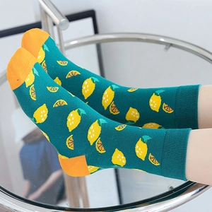 Detail of dark green cotton socks with lemon print and orange contrasting heel and toe