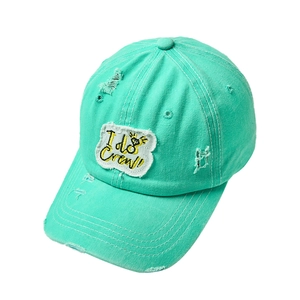 Detail of mint green distressed baseball cap featuring I do Crew embroidery and ring icon