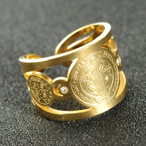 Macro view of gold-plated St. Benedict medal ring with sparkling rhinestones details