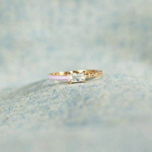 Detailed close-up of a gold ring featuring lavender enamel and rectangular zircon gemstone